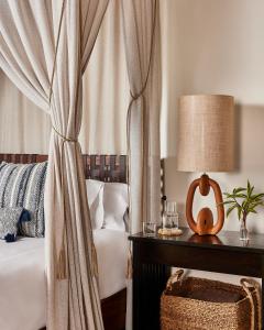 - une chambre avec un lit et une table avec une lampe dans l'établissement Hacienda AltaGracia, Auberge Resorts Collection, à Santa Elena