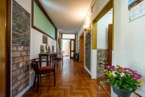 a hallway with a brick wall and chairs and flowers at VILLA LAGO GROUND FLOOR- Pet friendly stay-private garden-parking-Lake view - Bike friendly holiday house in Colico