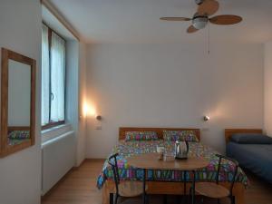 a bedroom with a bed and a table and a window at Agriturismo Fiordimelo-Camere in Tirano