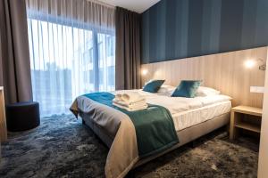 a hotel room with a bed and a large window at Hotel Zatoka in Gdańsk