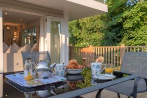 a table with a tea kettle and a bowl of food at Trewhiddle Retreat V11 by Together Travel - Luxury 4-Bedroom Villa in St Austell +36 photos
