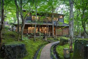 une maison dans les bois avec un chemin menant à celle-ci dans l'établissement Nihon-no-Ashitaba, à Yufu