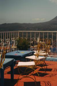 a patio with a table and chairs on a balcony at Hôtel Barcelona in Chefchaouen