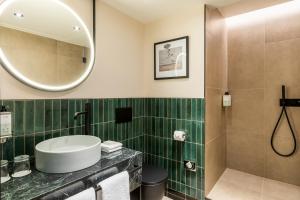 bagno con lavandino e specchio di Le Parchamp, a Tribute Portfolio Hotel, Paris Boulogne a Boulogne-Billancourt