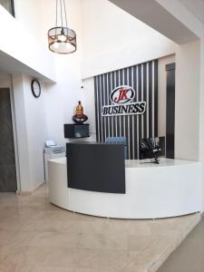 an office lobby with a reception desk and a business sign at JK BUSINESS HOTEL in Denizli