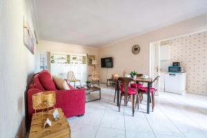a living room with a red couch and a table at La Brise Marine - Appt avec balcon 50m de la plage in Arcachon