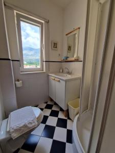 a bathroom with a black and white checkered floor at Vila Lukić in Slano