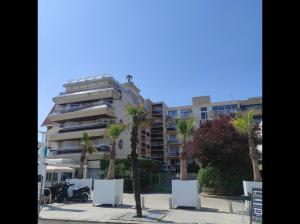 a tall building with palm trees in front of it at La Brise Marine - Appt avec balcon 50m de la plage in Arcachon