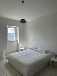 um quarto branco com uma cama grande e uma janela em Casita1906 em Rocchetta a Volturno