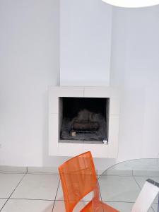an orange chair in a room with a fireplace at Casita1906 in Rocchetta a Volturno