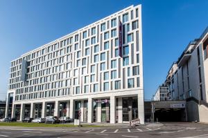 ein großes weißes Gebäude in einer Stadtstraße in der Unterkunft Premier Inn Stuttgart City Centre in Stuttgart