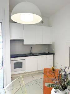a kitchen with white cabinets and a glass table at Casita1906 in Rocchetta a Volturno