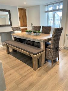 a dining room with a wooden table and chairs at The Little Seahorse - Newly Renovated Cottage 5mins Walk The Beach with Hot Tub in Tywardreath