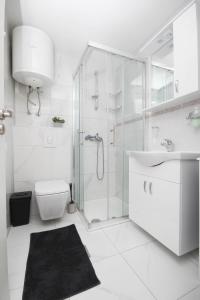 La salle de bains est pourvue d'une douche, de toilettes et d'un lavabo. dans l'établissement Dusica apartments, à Tribunj