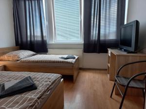 Kleines Zimmer mit 2 Betten und einem TV in der Unterkunft Penzión Tina in Prešov