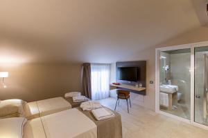 a hotel room with a bed and a television at Charme SIMON BOLIVAR in Noto