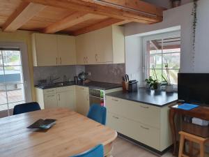 a kitchen with a wooden table and a dining room at Au Château in Lajoux