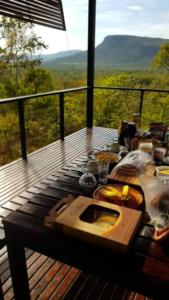 una mesa en una terraza con vistas a las montañas en Casa da Serra en Cavalcante