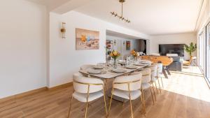 une salle à manger avec une grande table et des chaises dans l'établissement Villa Hakuna Matata - 4 étoiles climatisée avec piscine, à Saint-Médard-en-Jalles