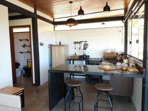 a kitchen with a large counter with stools in it at Casa da Serra in Cavalcante