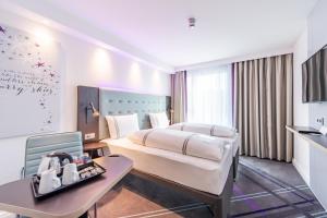 a hotel room with a bed and a table at Premier Inn Stuttgart City Centre in Stuttgart