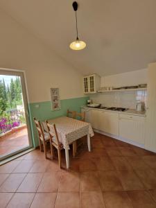 a kitchen with a table and chairs and a table and a table and a kitchen at Vila Lukić in Slano
