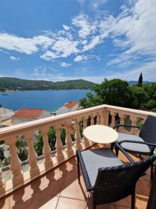 a balcony with a table and chairs and a view of a lake at Vila Lukić in Slano
