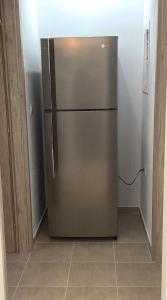 a stainless steel refrigerator in the corner of a kitchen at MARMARI apartments in Ayía Marína