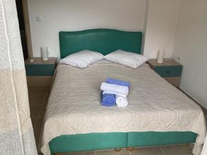 a bed with two towels and two pillows on it at MARMARI apartments in Ayía Marína