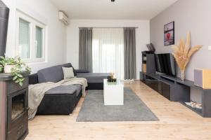 a living room with a couch and a tv at Holiday Home Bibano in Bibinje