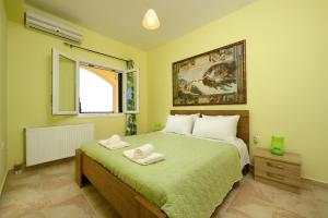 a bedroom with a bed with two towels on it at Nisos Sunset Apartments Agios Gordios in Corfu Town