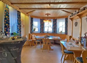 uma sala de jantar com mesa, cadeiras e janelas em Kastanienhof em Bad Steben