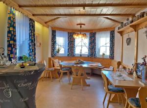 a dining room with a table and chairs and windows at Kastanienhof in Bad Steben