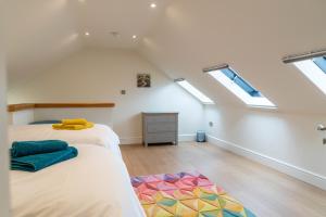 a attic bedroom with two beds and skylights at The Old Threshing Barn in Newark upon Trent