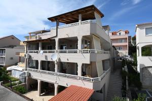 a white apartment building with a balcony at Guest house Kokolo in Hvar