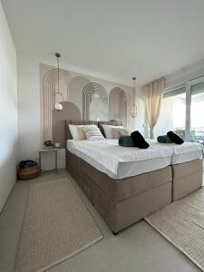 Luxury apartment Golden Mint في نوفاليا: غرفة نوم بسرير كبير عليها شراشف ووسائد بيضاء