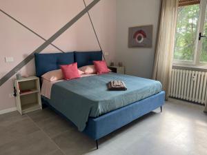 Rosa di Parma في بارما: سرير أزرق مع وسائد وردية في غرفة النوم