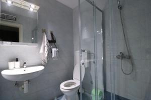 uma casa de banho com um chuveiro, um WC e um lavatório. em Flat 23 em Belgrado