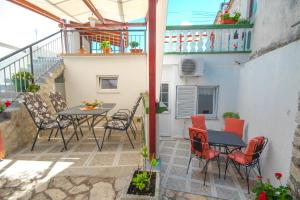 un patio con tavolo e sedie su un balcone di Dusica apartments a Tribunj (Trebocconi)