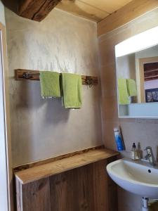 uma casa de banho com um lavatório e um espelho em Au Château em Lajoux