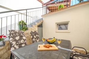 un tavolo con due bicchieri di vino e una ciotola di banane di Dusica apartments a Tribunj (Trebocconi) Altre 25 foto
