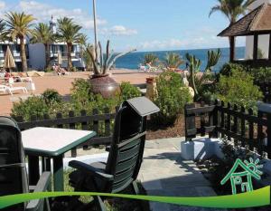 a patio with a table and chairs and the ocean at Bonito apartamento con vista al mar in Playa del Aguila