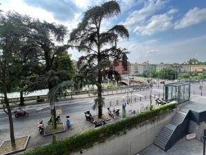 een straat met mensen op banken en bomen bij Rosa di Parma in Parma