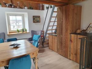 comedor con mesa de madera y sillas azules en Au Château, en Lajoux