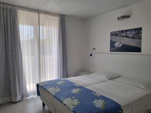 a bedroom with a bed and a large window at Appart-Hotel Holiday in Lignano Sabbiadoro
