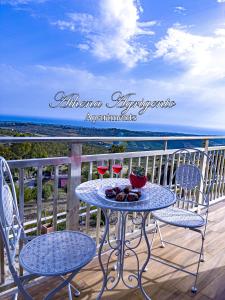 una mesa y sillas en un balcón con vistas al océano en Athena Agrigento Apartments, en Agrigento