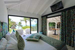 a bedroom with a bed with a view of the ocean at La Toubana Hotel & Spa in Sainte-Anne