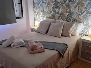 een slaapkamer met een bed met handdoeken erop bij Ático Estrella sunset in Corralejo