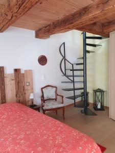 a bedroom with a red bed and a spiral staircase at Au Château in Lajoux