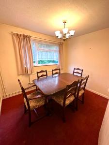 a dining room with a wooden table and chairs at Rochester town centre beautiful 3-Bedroom House with garden in Strood